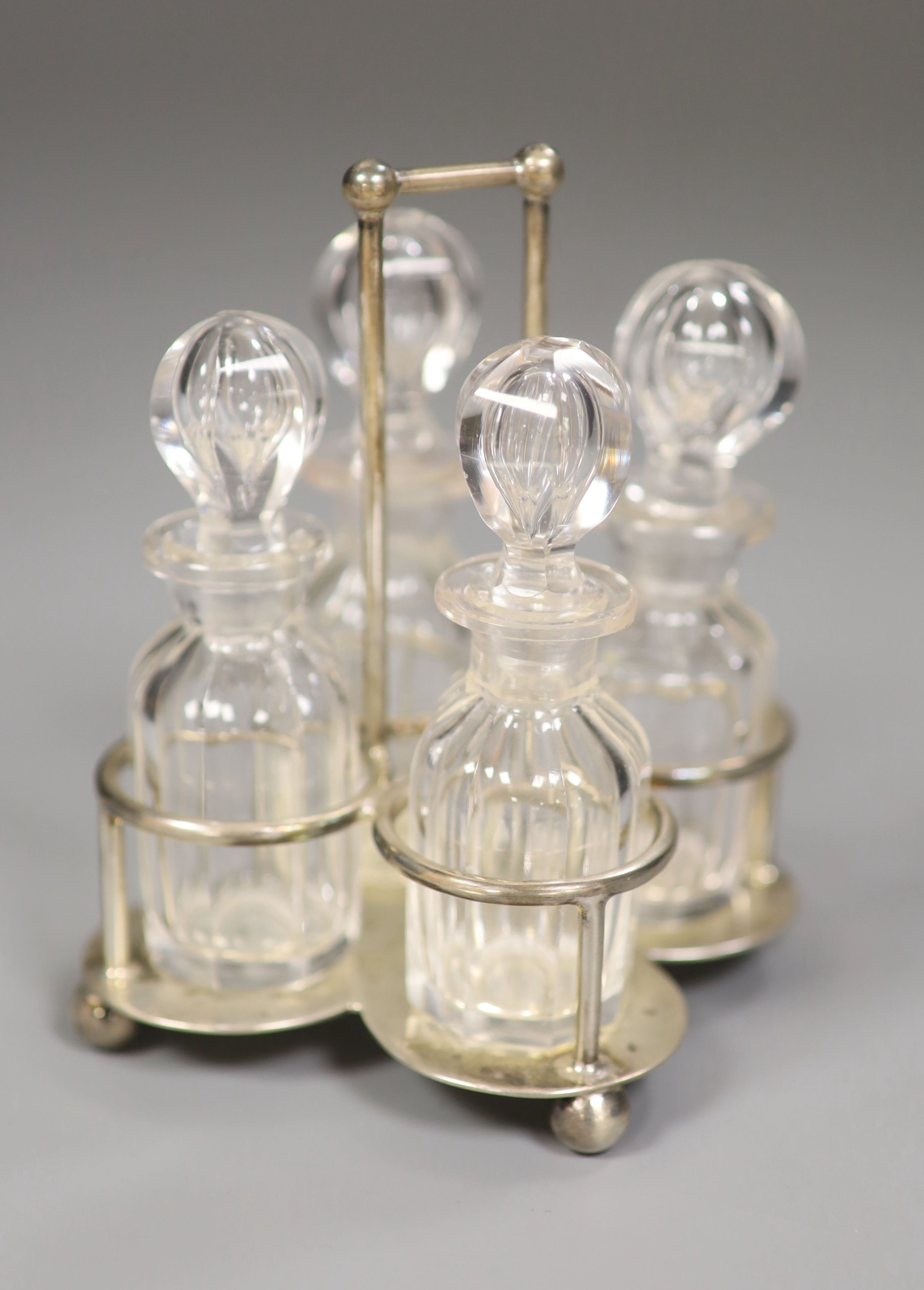 A small Edwardian silver cruet stand, with four glass cruets, Goldsmiths & Silversmiths Co Ltd, London 1901, height 12cm, 4oz.